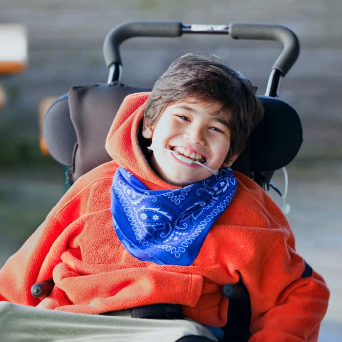 Young boy wearing a mouth brace in a wheelchair