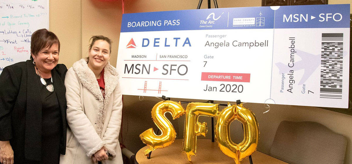 Job Coach Kathy Walters and self-advocate Angela Campbell pose for a photo with the “boarding pass” for their round-trip flight to San Francisco.